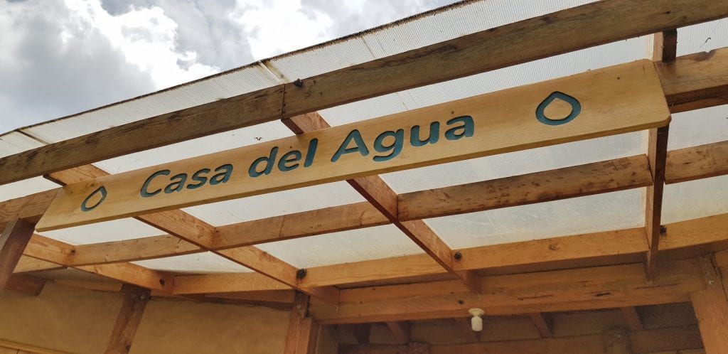A wooden building with the words Casa del Agua written on it in blue.